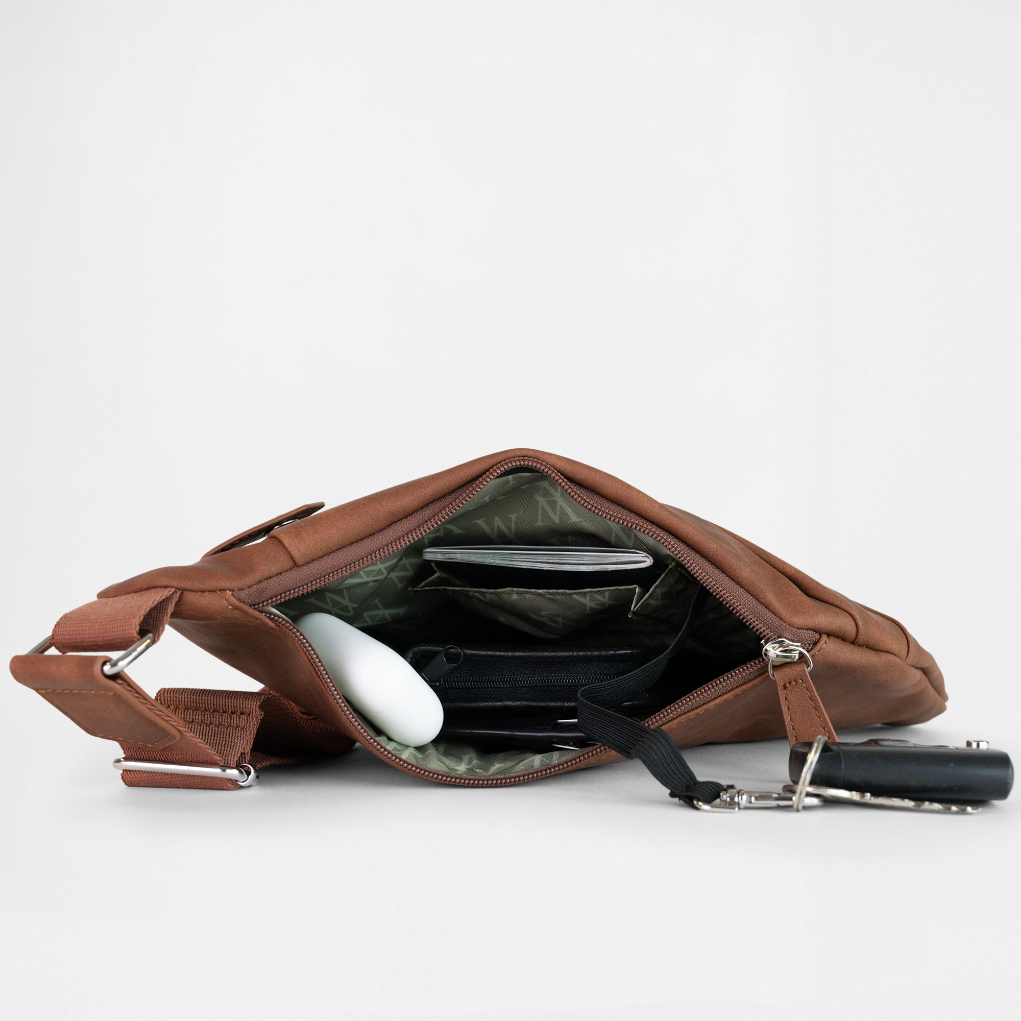 Interior view of the London Sling Bag in Cognac, showing internal compartments, organised essentials and keychain clip.