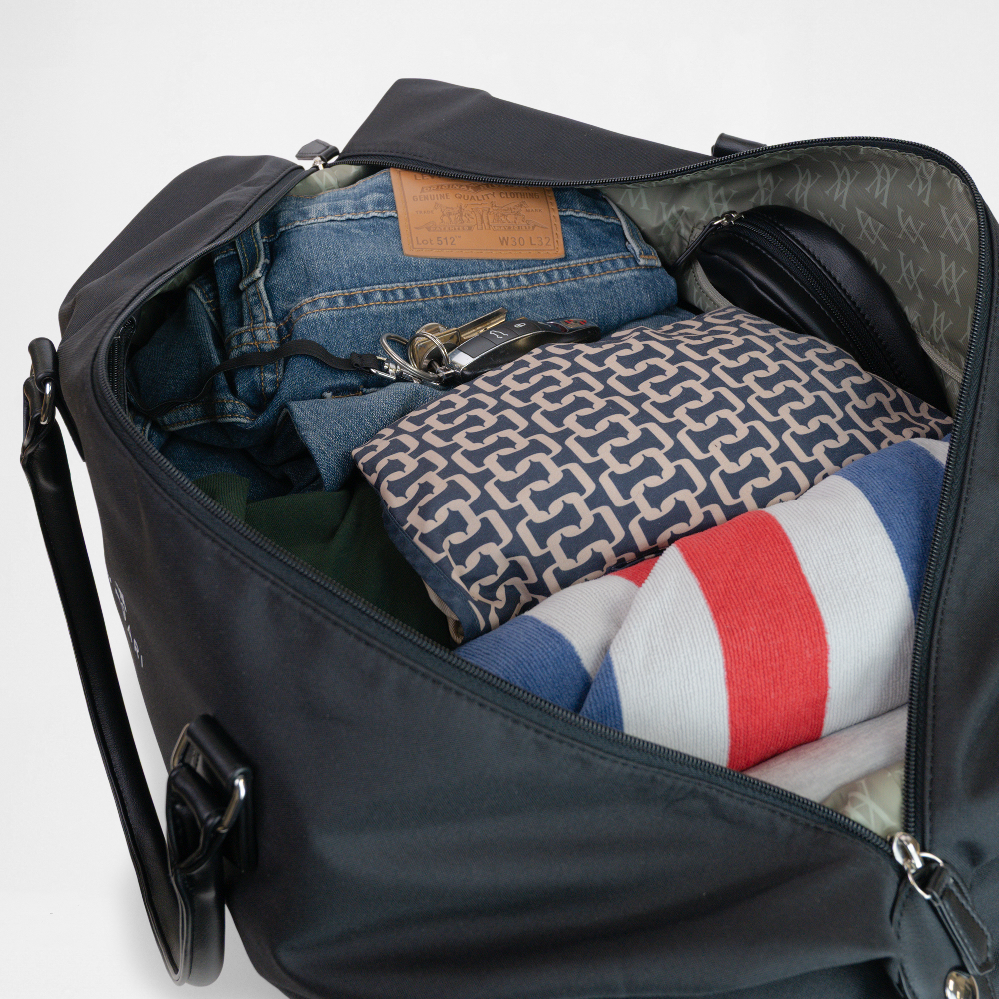 Interior view of the Athens Gym Bag in Black packed with clothes, keys, and essentials