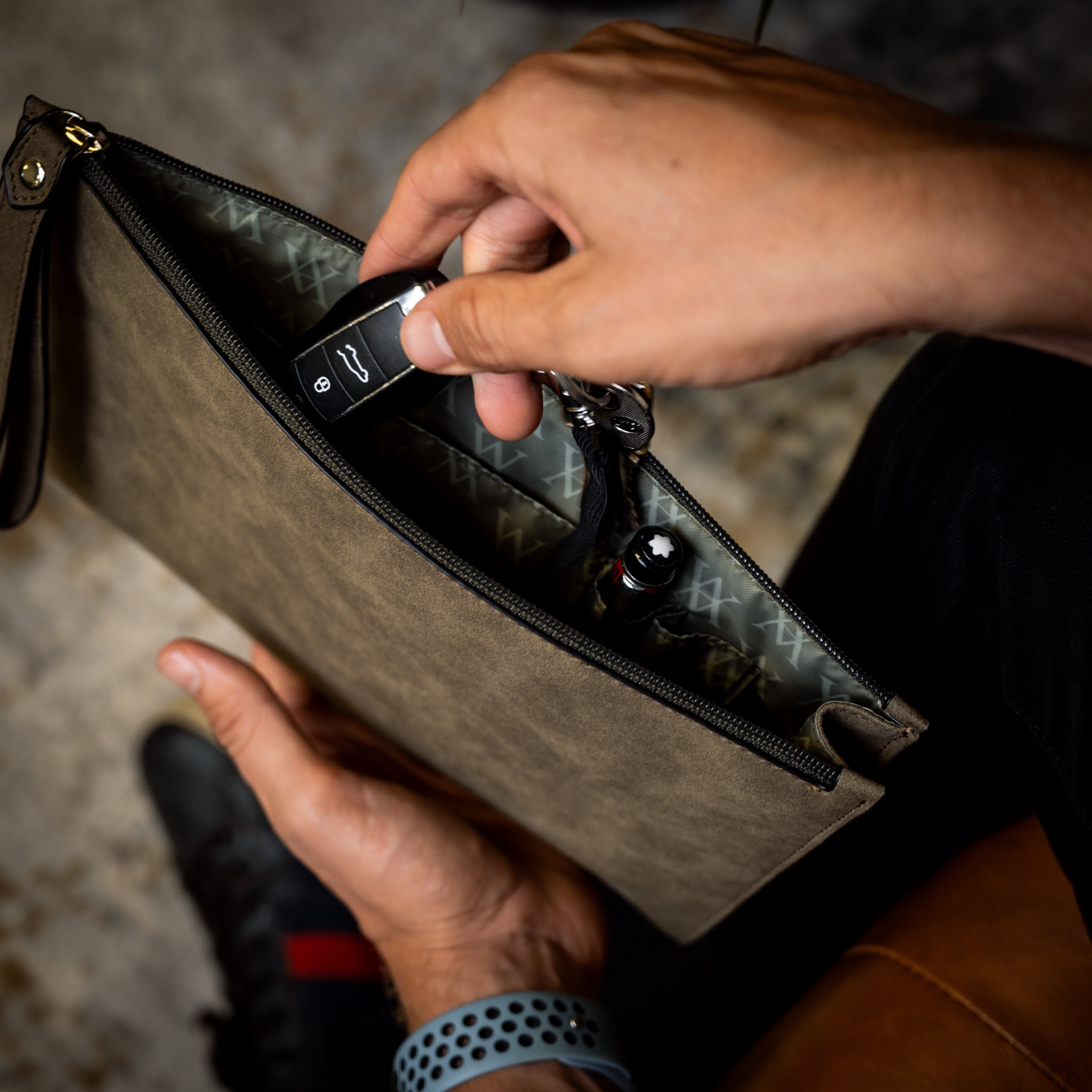 Lifestyle POV of the Geneva Compact Pouch in Olive Drab, shown in hand with keys attached to clip.