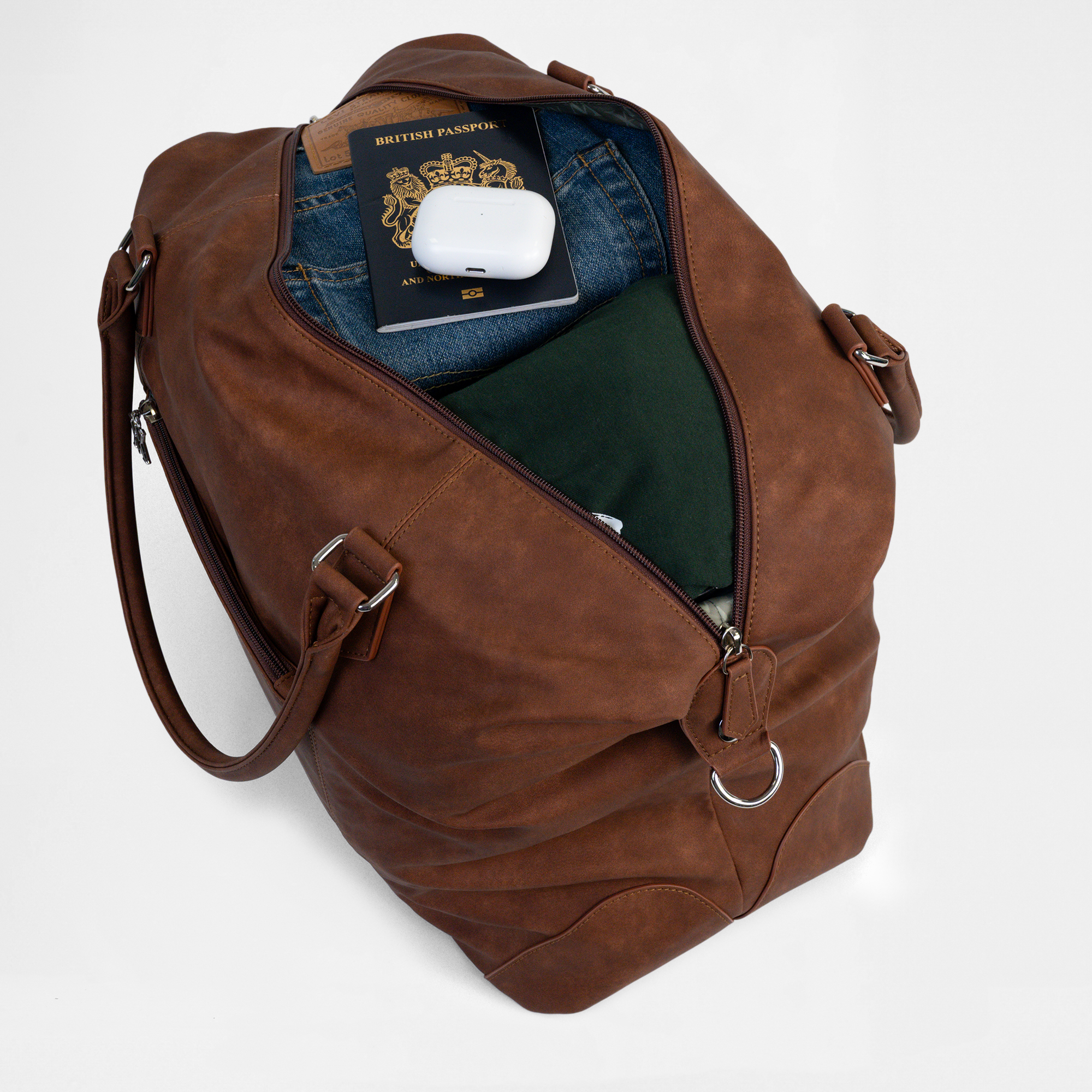Open top view of the Lisbon Weekender in Cognac, packed with travel items including passport and AirPods.