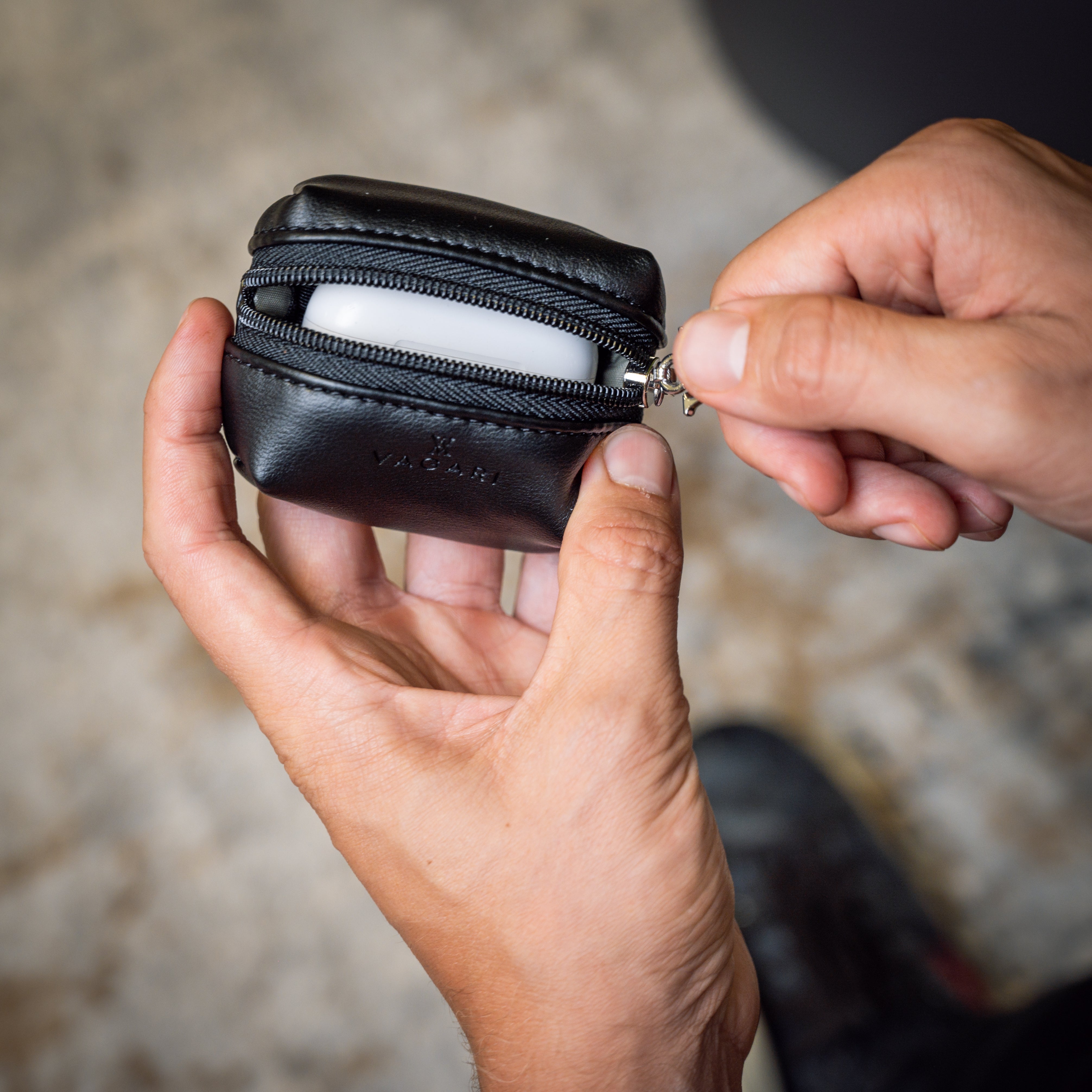 Lifestyle POV of the Memphis Earbud Case in Black being opened to reveal earbuds