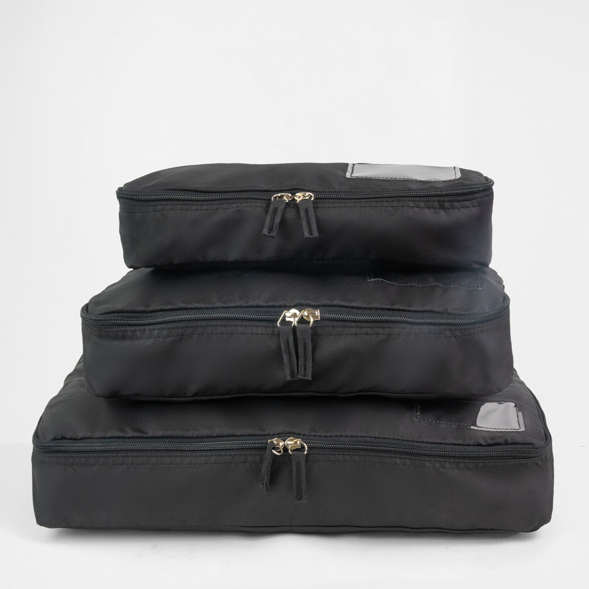 A set of three black packing cubes of different sizes stacked.
